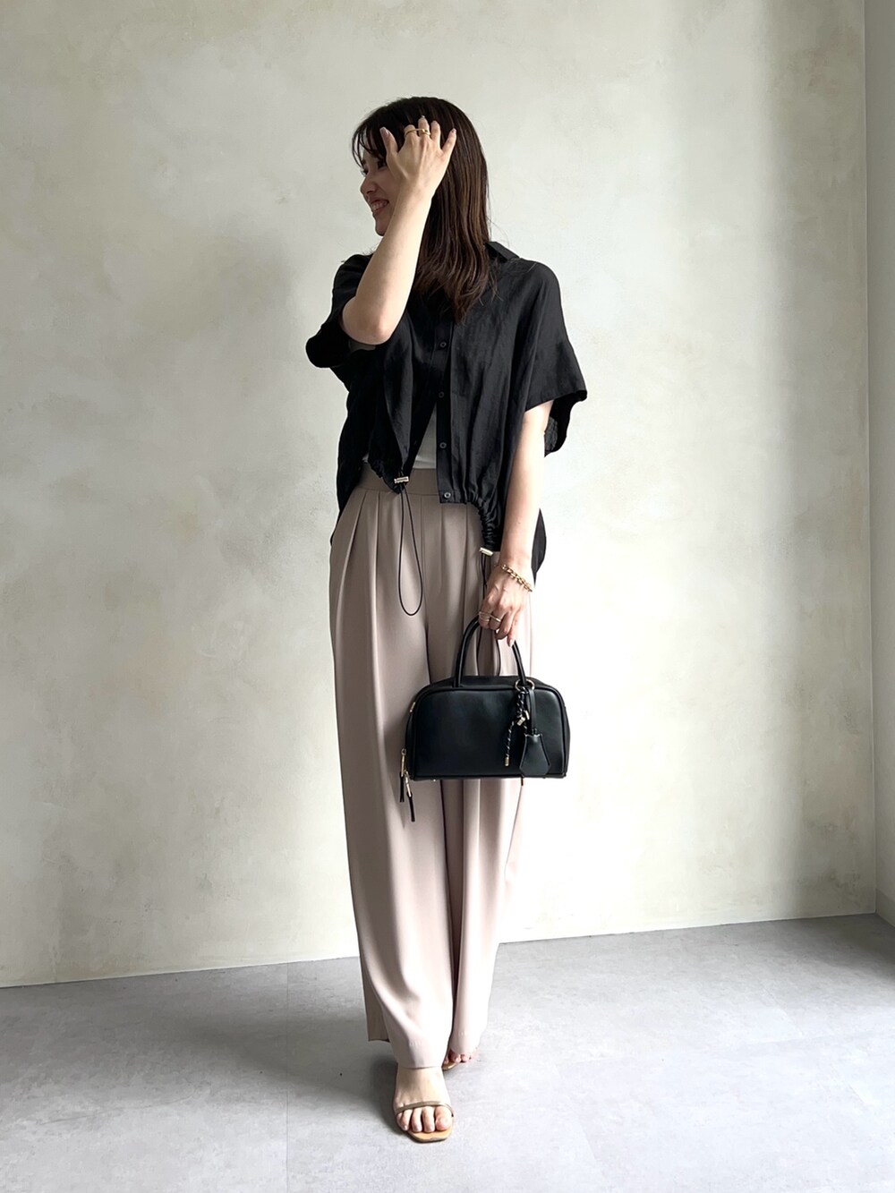 ブラック系のシャツ/ブラウス、ホワイト系のTシャツ/カットソー、ベージュ系のスラックスを着用したレディースの夏コーディネートの2枚目の写真