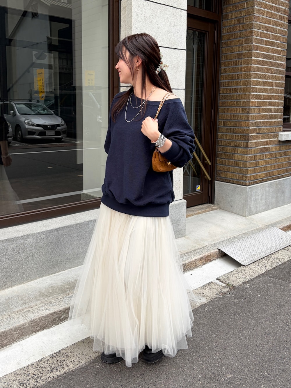 ブルー系のTシャツ/カットソー、ホワイト系のスカート、イエロー系のショルダーバッグを着用したレディースの冬コーディネートの3枚目の写真