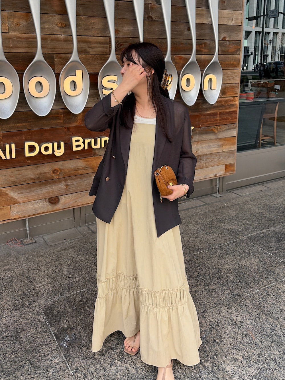 グレー系のテーラードジャケット、ベージュ系のワンピースを着用したレディースの春コーディネートの2枚目の写真