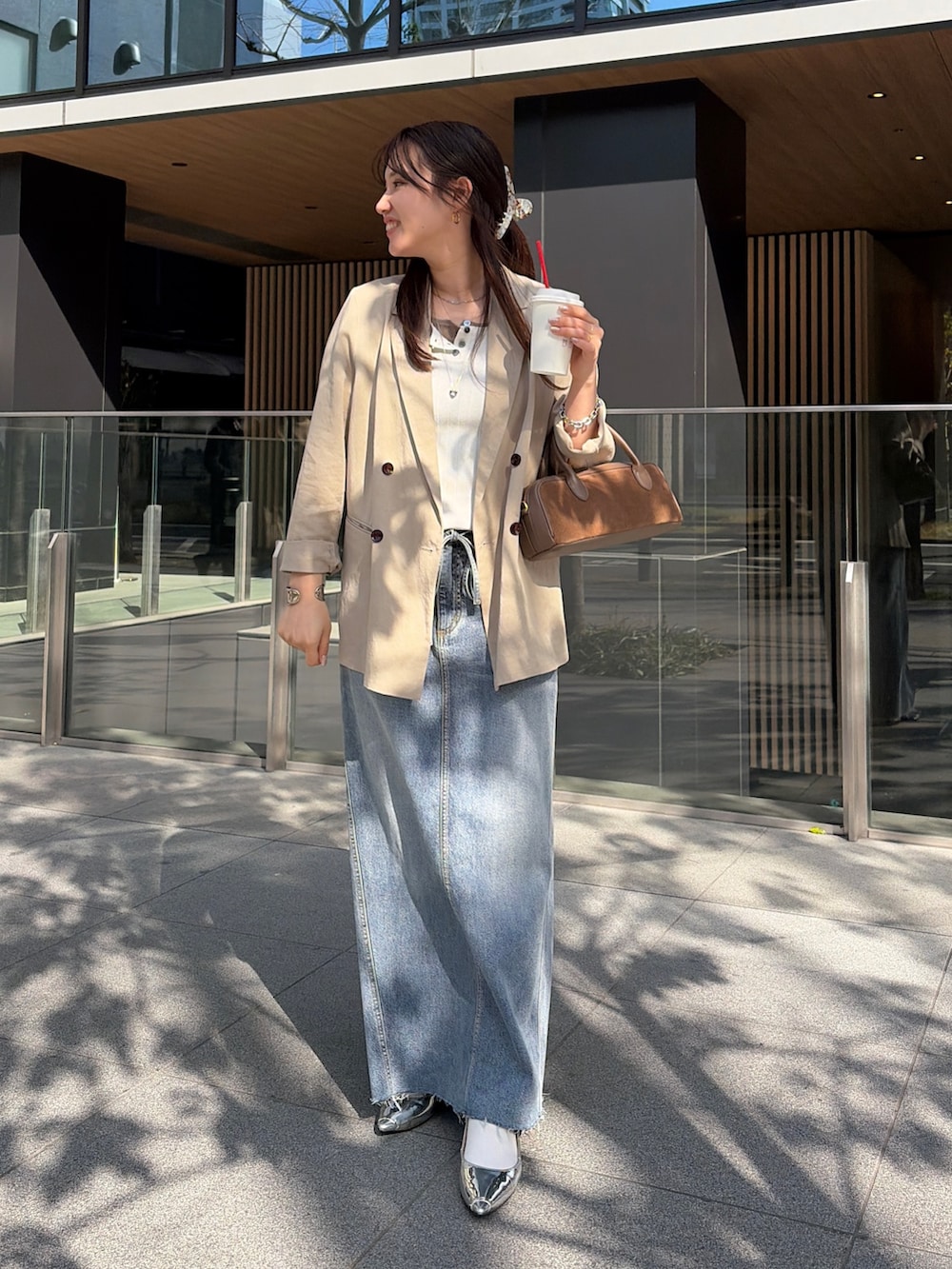 ホワイト系のニット/セーター、ブルー系のスカート、ベージュ系のテーラードジャケットを着用したレディースの春コーディネートの2枚目の写真