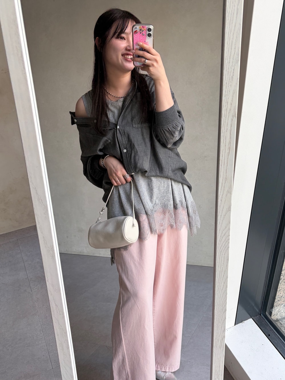 ブラック系のシャツ/ブラウス、グレー系のTシャツ/カットソー、ピンク系のデニムパンツを着用したレディースの春コーディネートの3枚目の写真