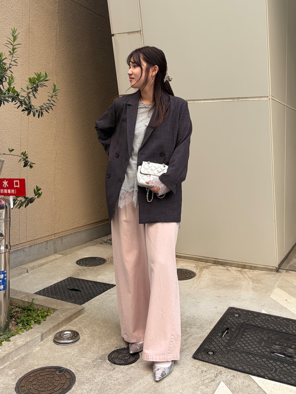 グレー系のテーラードジャケット、グレー系のTシャツ/カットソー、ピンク系のデニムパンツを着用したレディースの冬コーディネートの2枚目の写真