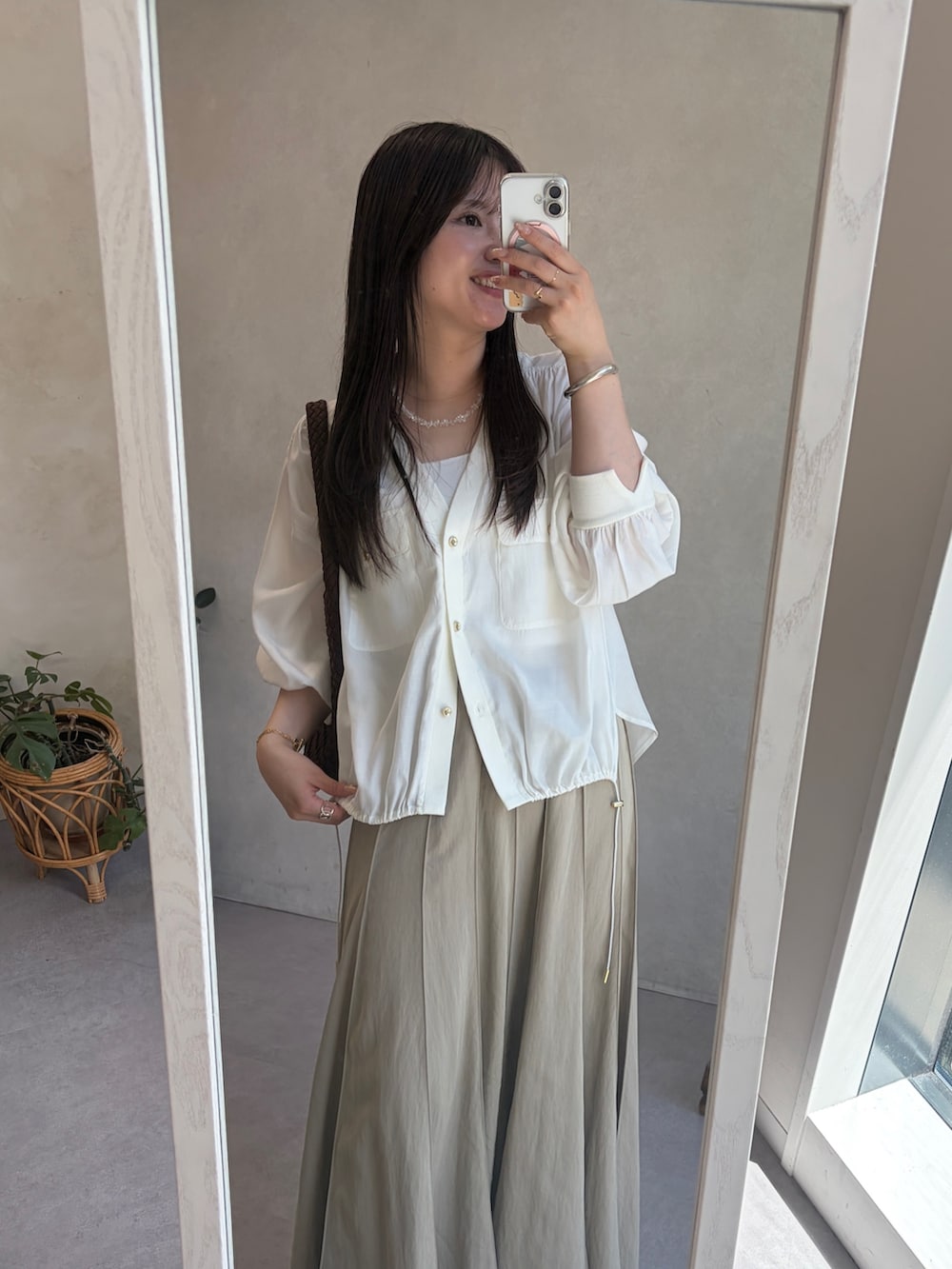 ホワイト系のシャツ/ブラウス、ベージュ系のスカート、ブラウン系のトートバッグを着用したレディースの夏コーディネートの2枚目の写真