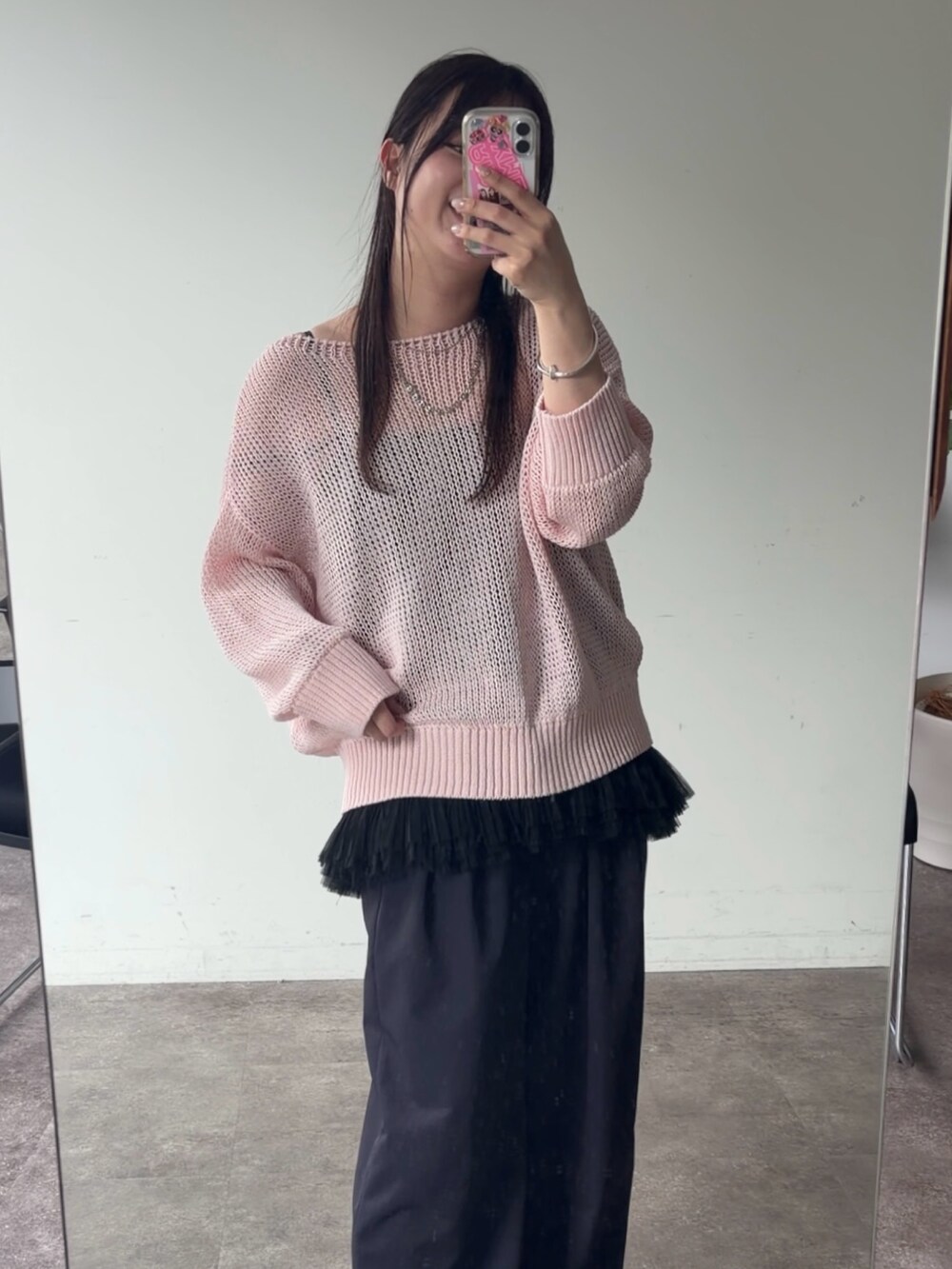 ブラック系のシャツ/ブラウス、ピンク系のニット/セーター、シルバー系のネックレスを着用したレディースの春コーディネートの2枚目の写真