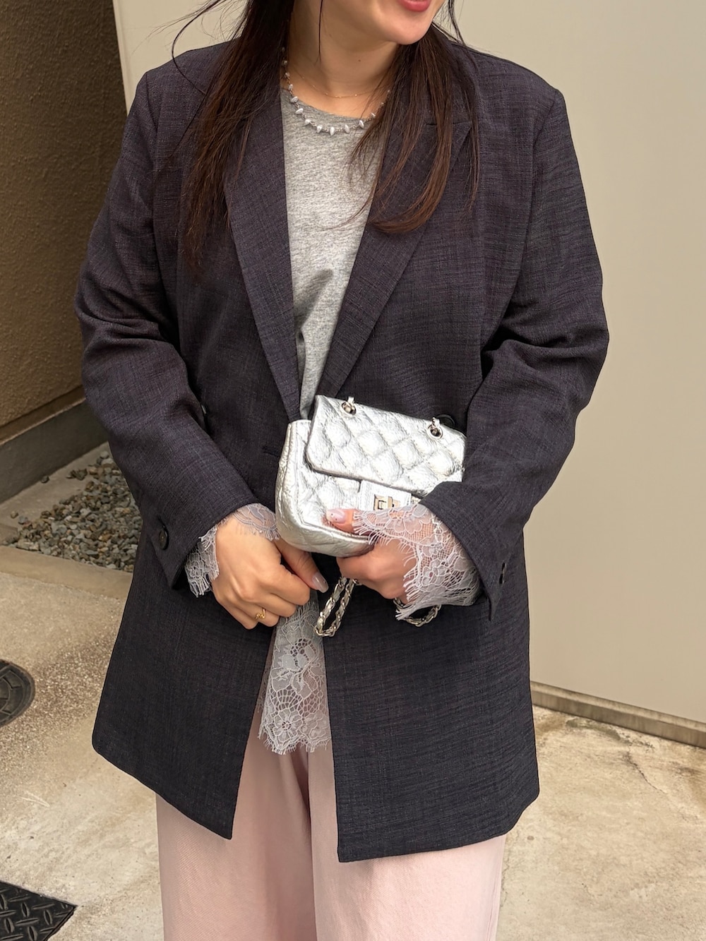 グレー系のテーラードジャケット、グレー系のTシャツ/カットソー、ピンク系のデニムパンツを着用したレディースの冬コーディネートの5枚目の写真