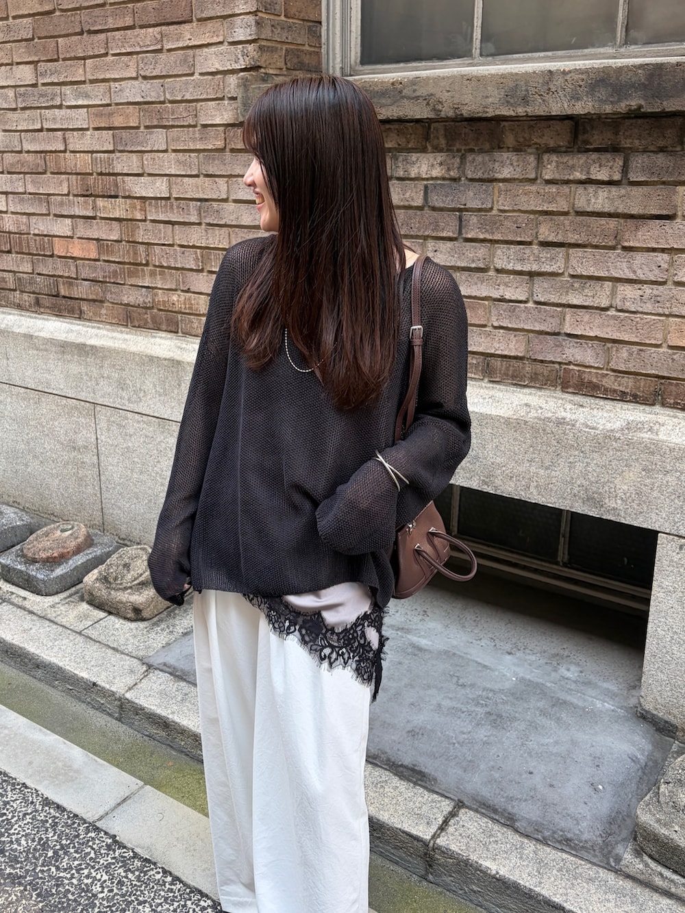 グレー系のシャツ/ブラウス、ブラック系のニット/セーター、ホワイト系のその他パンツを着用したレディースの夏コーディネートの4枚目の写真