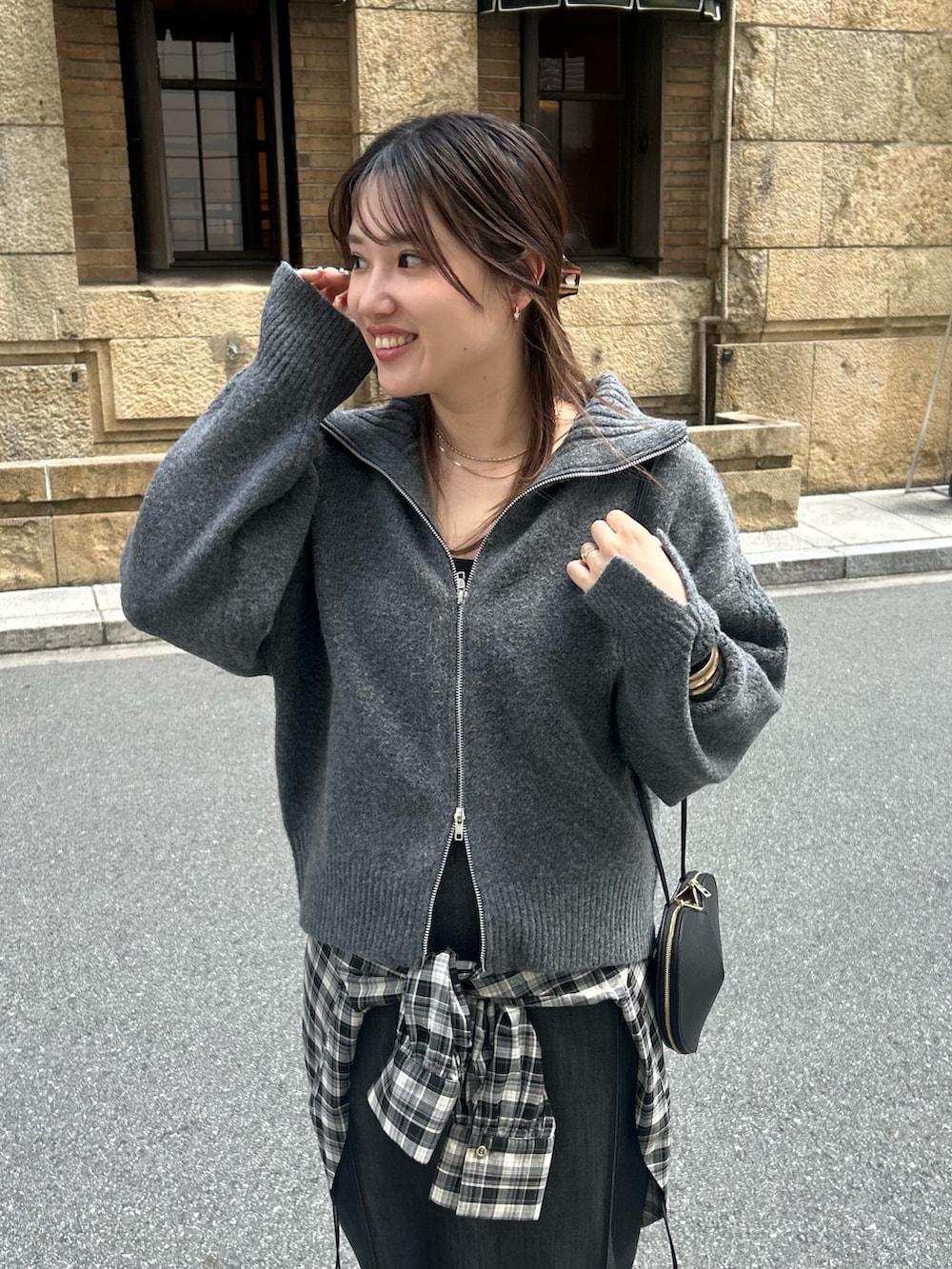 グレー系のカーディガン/ボレロ、グレー系のシャツ/ブラウス、ブラック系のスカートを着用したレディースの秋コーディネートの3枚目の写真