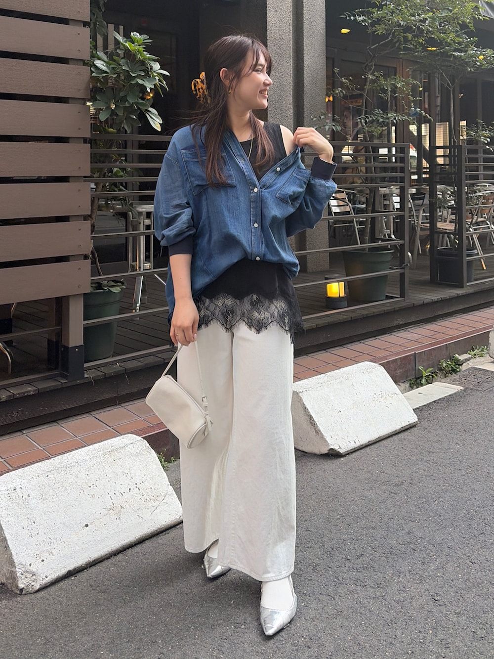 ブルー系のシャツ/ブラウス、ブラック系のTシャツ/カットソー、ホワイト系のデニムパンツを着用したレディースの春コーディネートの2枚目の写真