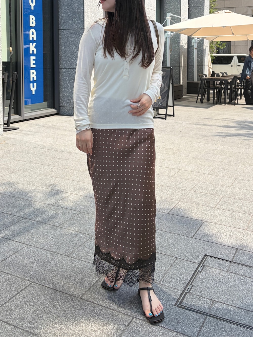 ホワイト系のTシャツ/カットソー、ブラウン系のスカート、グリーン系のトートバッグを着用したレディースの夏コーディネートの2枚目の写真