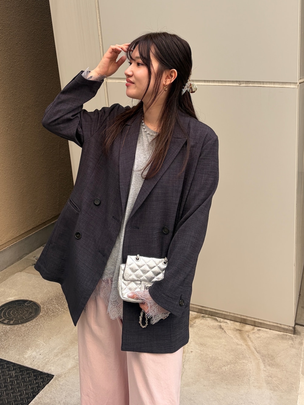 グレー系のテーラードジャケット、グレー系のTシャツ/カットソー、ピンク系のデニムパンツを着用したレディースの冬コーディネートの4枚目の写真