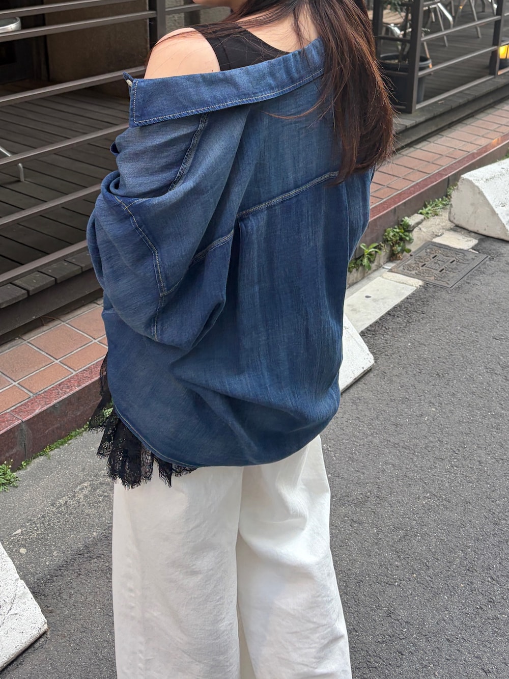 ブルー系のシャツ/ブラウス、ブラック系のTシャツ/カットソー、ホワイト系のデニムパンツを着用したレディースの春コーディネートの5枚目の写真