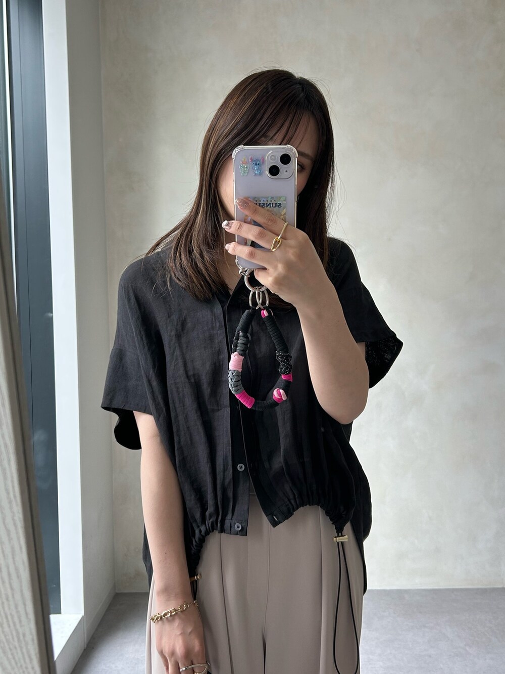 ブラック系のシャツ/ブラウス、ホワイト系のTシャツ/カットソー、ベージュ系のスラックスを着用したレディースの夏コーディネートの5枚目の写真