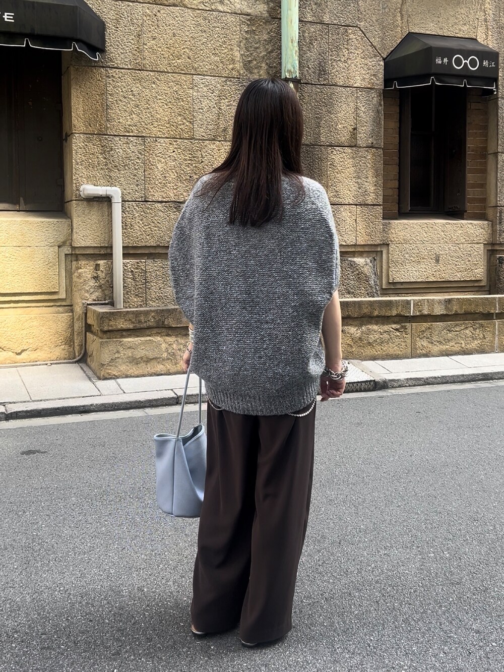 グレー系のカーディガン/ボレロ、ブラウン系のスラックス、ブルー系のショルダーバッグを着用したレディースの夏コーディネートの4枚目の写真