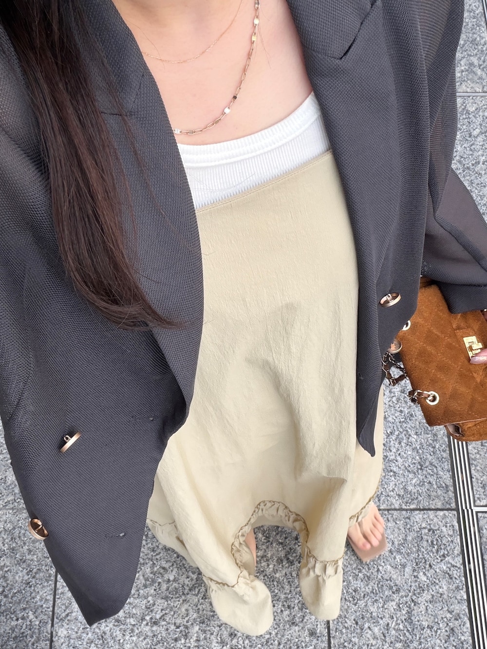 グレー系のテーラードジャケット、ベージュ系のワンピースを着用したレディースの春コーディネートの3枚目の写真