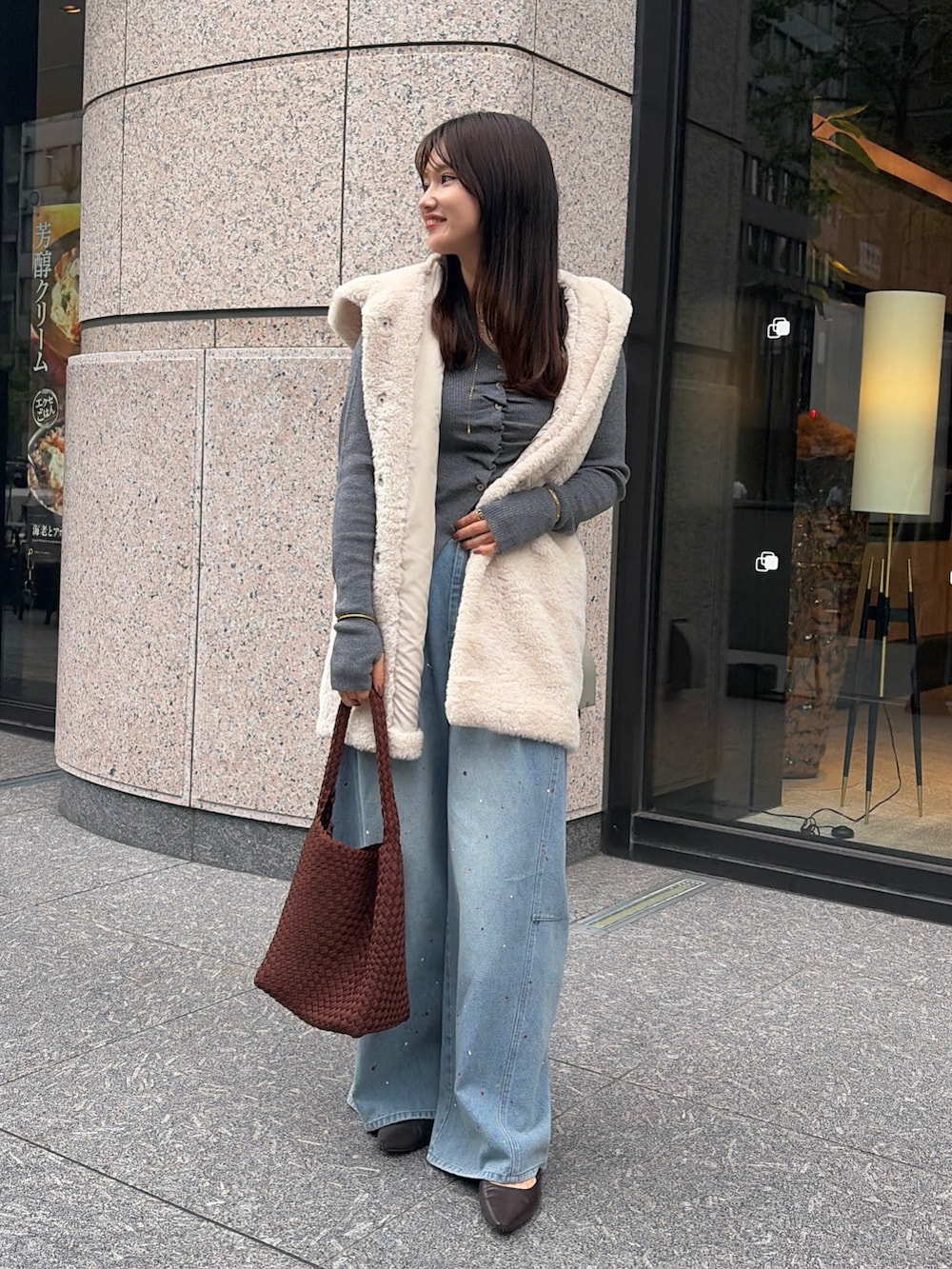 ホワイト系のベスト、ブルー系のその他パンツ、ブラウン系のトートバッグを着用したレディースの秋コーディネートの2枚目の写真