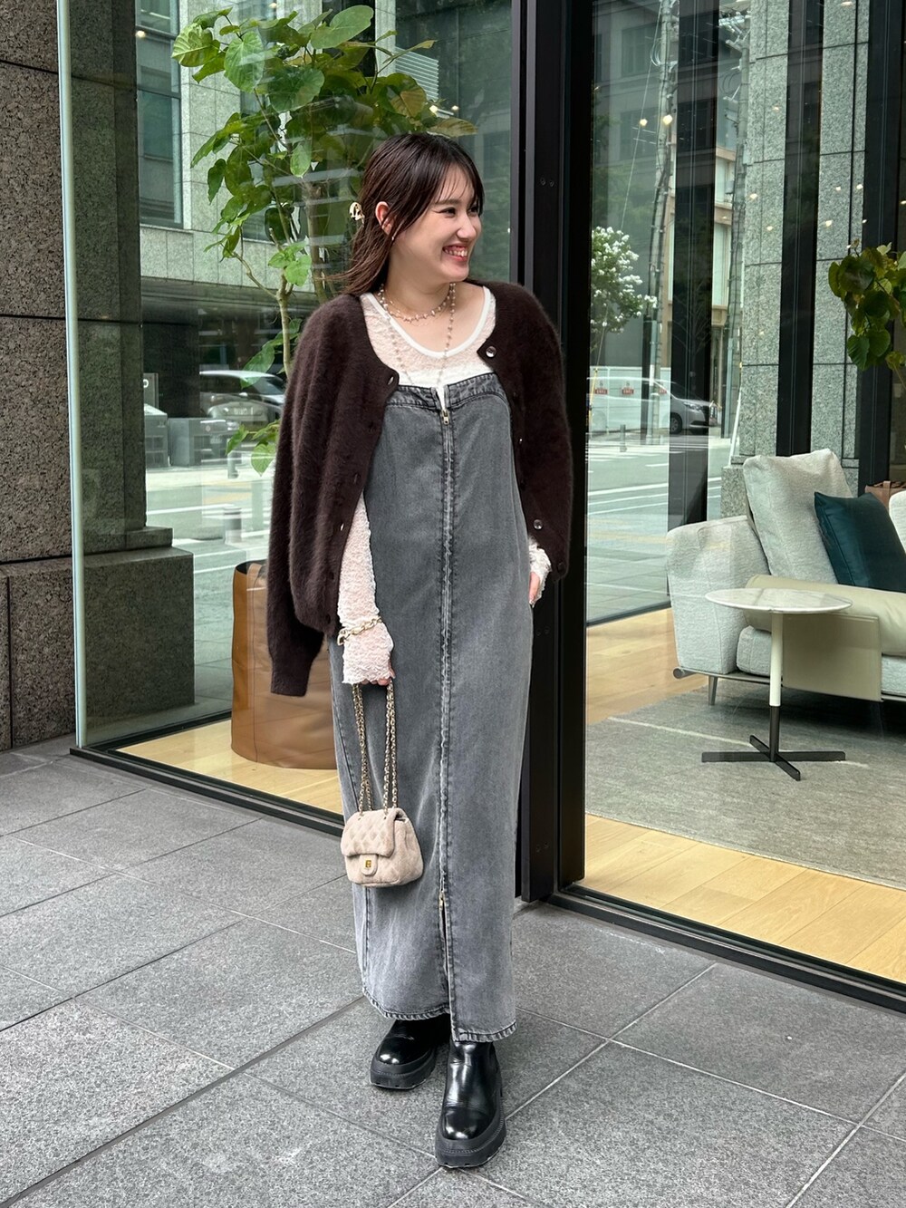 ブラック系のワンピース、ブラウン系のカーディガン/ボレロ、グレー系のショルダーバッグを着用したレディースの秋コーディネートの3枚目の写真