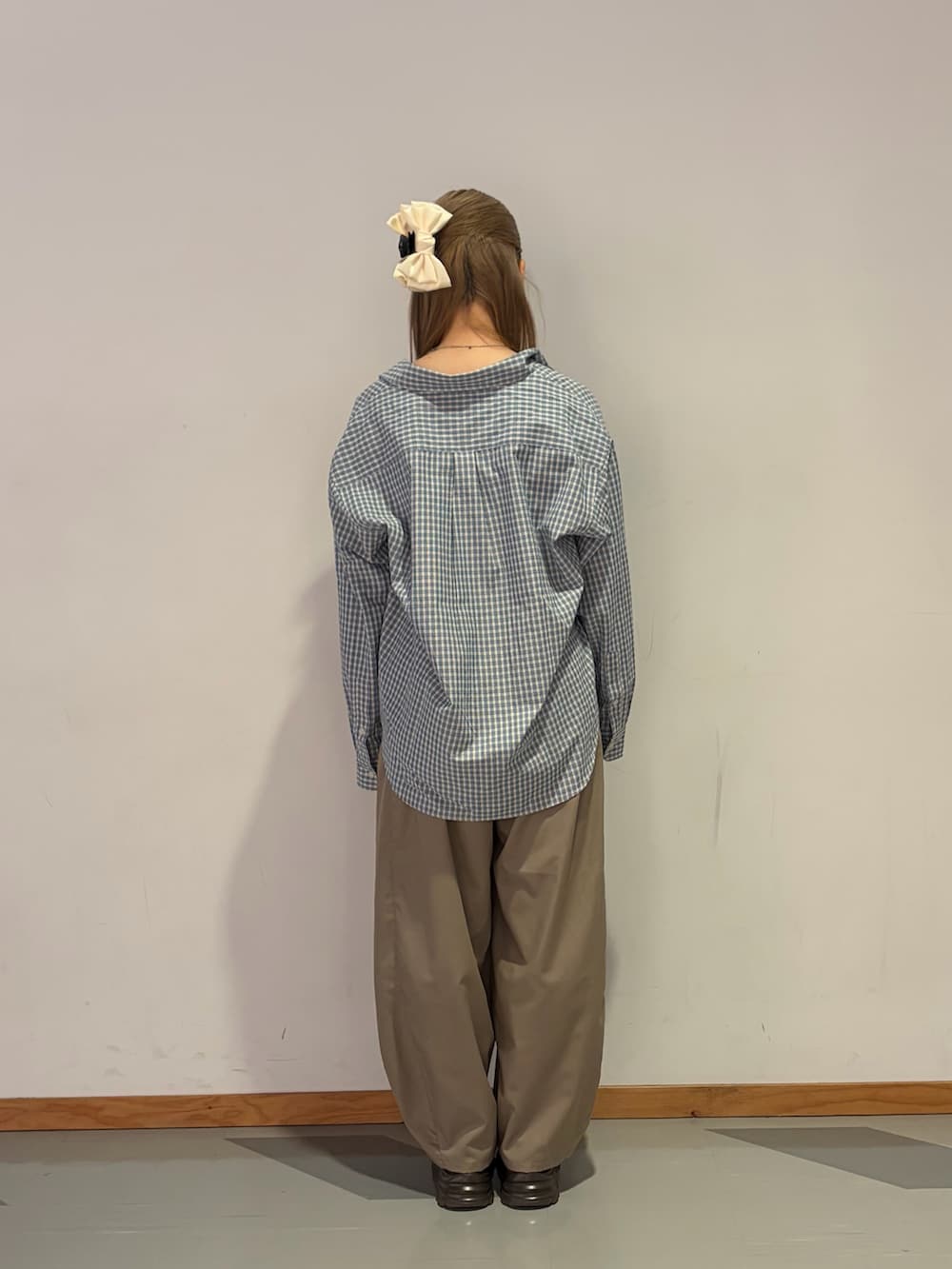 ブルー系のシャツ/ブラウス、ベージュ系のスラックスを着用したレディースの春コーディネートの3枚目の写真