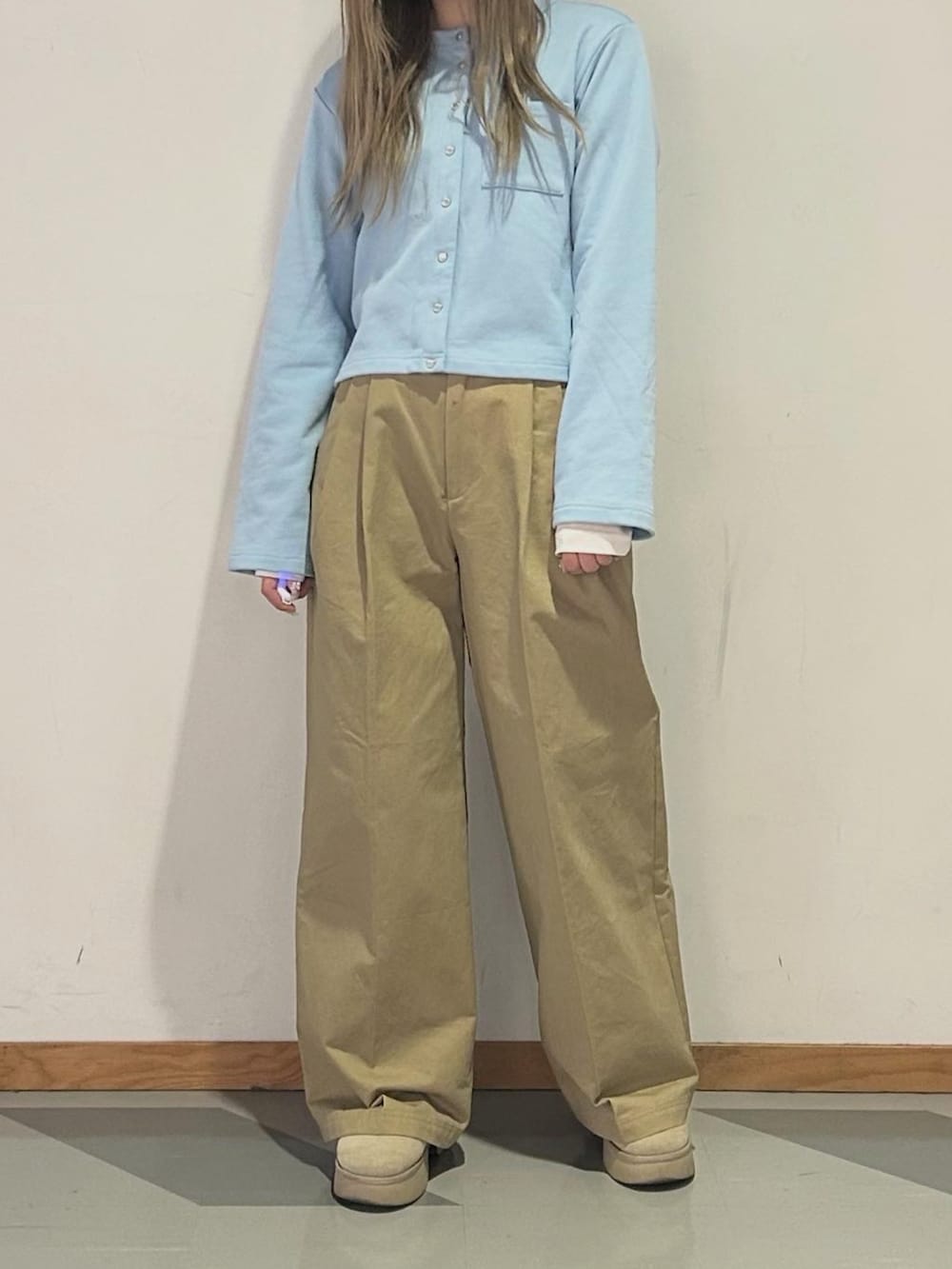 ブルー系のカーディガン/ボレロ、ホワイト系のTシャツ/カットソー、ベージュ系のチノパンツを着用したレディースの冬コーディネートの4枚目の写真