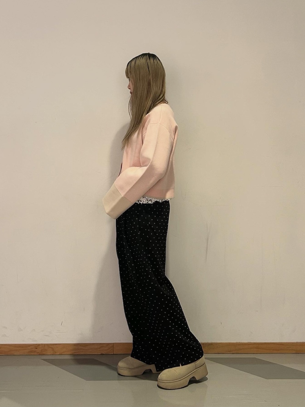 ブラック系のスラックス、ピンク系のカーディガン/ボレロ、ホワイト系のTシャツ/カットソーを着用したレディースの春コーディネートの2枚目の写真