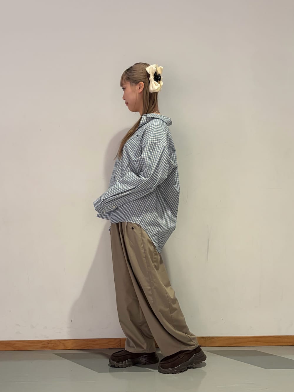 ブルー系のシャツ/ブラウス、ベージュ系のスラックスを着用したレディースの春コーディネートの2枚目の写真