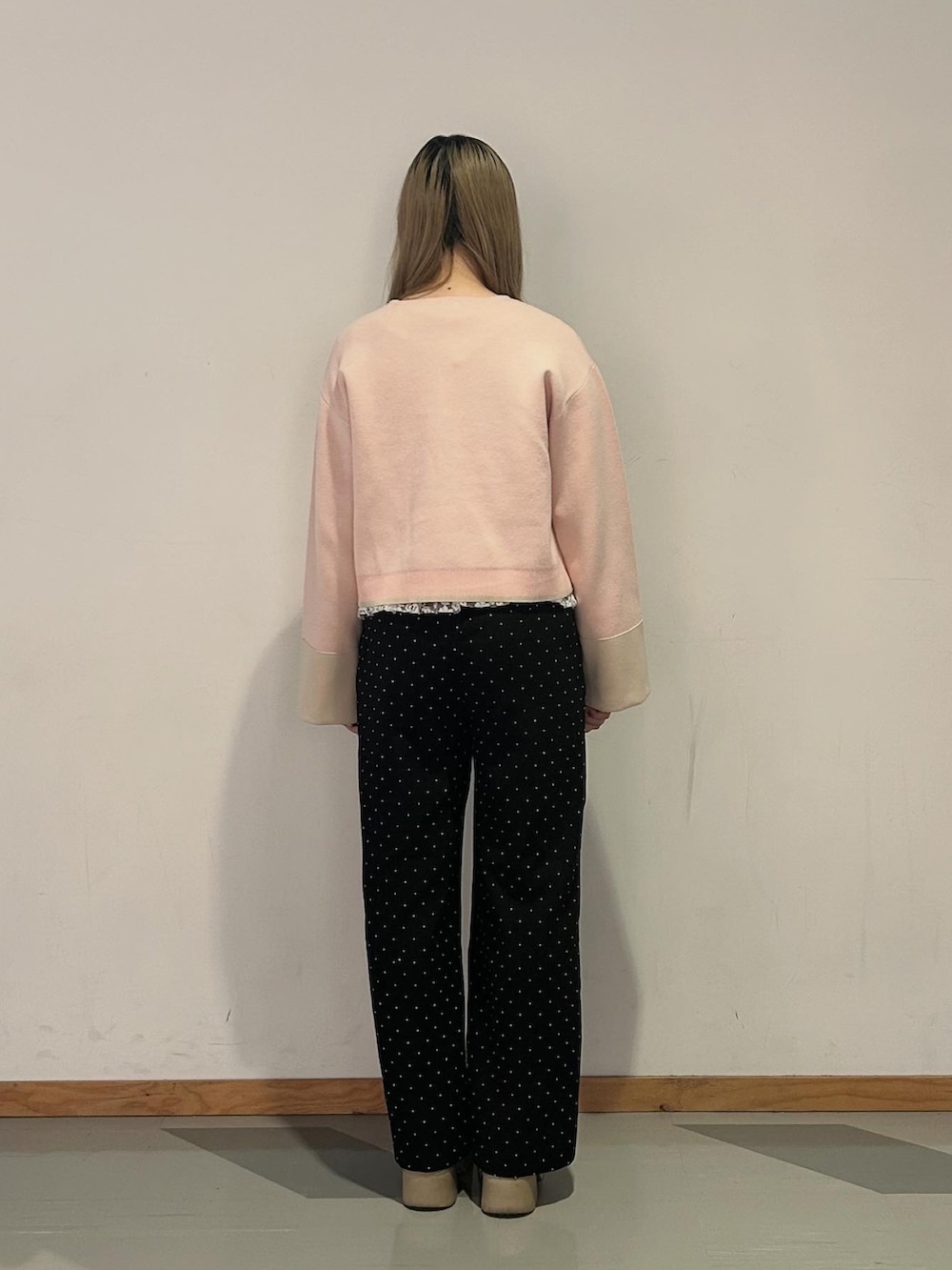 ブラック系のスラックス、ピンク系のカーディガン/ボレロ、ホワイト系のTシャツ/カットソーを着用したレディースの春コーディネートの3枚目の写真