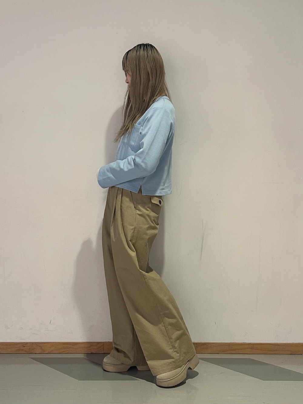 ブルー系のカーディガン/ボレロ、ホワイト系のTシャツ/カットソー、ベージュ系のチノパンツを着用したレディースの冬コーディネートの2枚目の写真