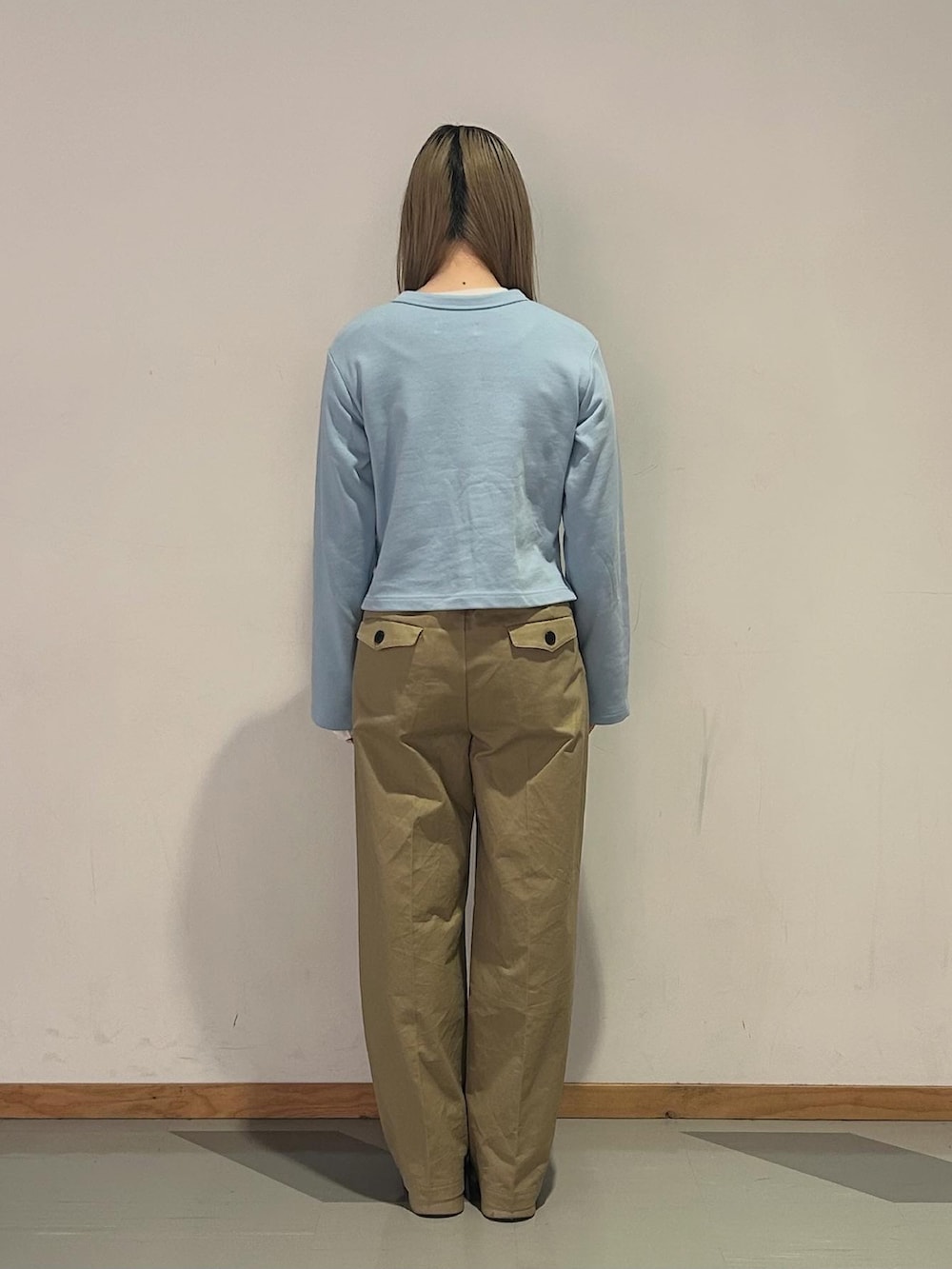 ブルー系のカーディガン/ボレロ、ホワイト系のTシャツ/カットソー、ベージュ系のチノパンツを着用したレディースの冬コーディネートの3枚目の写真