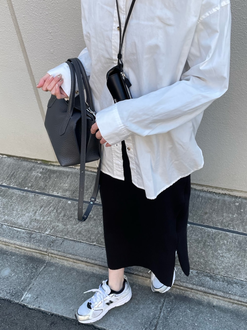 グレー系のトートバッグ、ブラック系のその他小物を着用したレディースの冬コーディネートの2枚目の写真