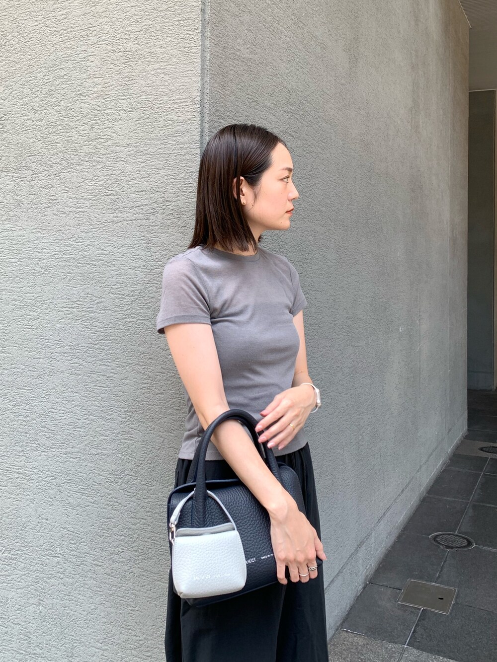 ブルー系のショルダーバッグ、グレー系のその他小物を着用したレディースの夏コーディネートの2枚目の写真