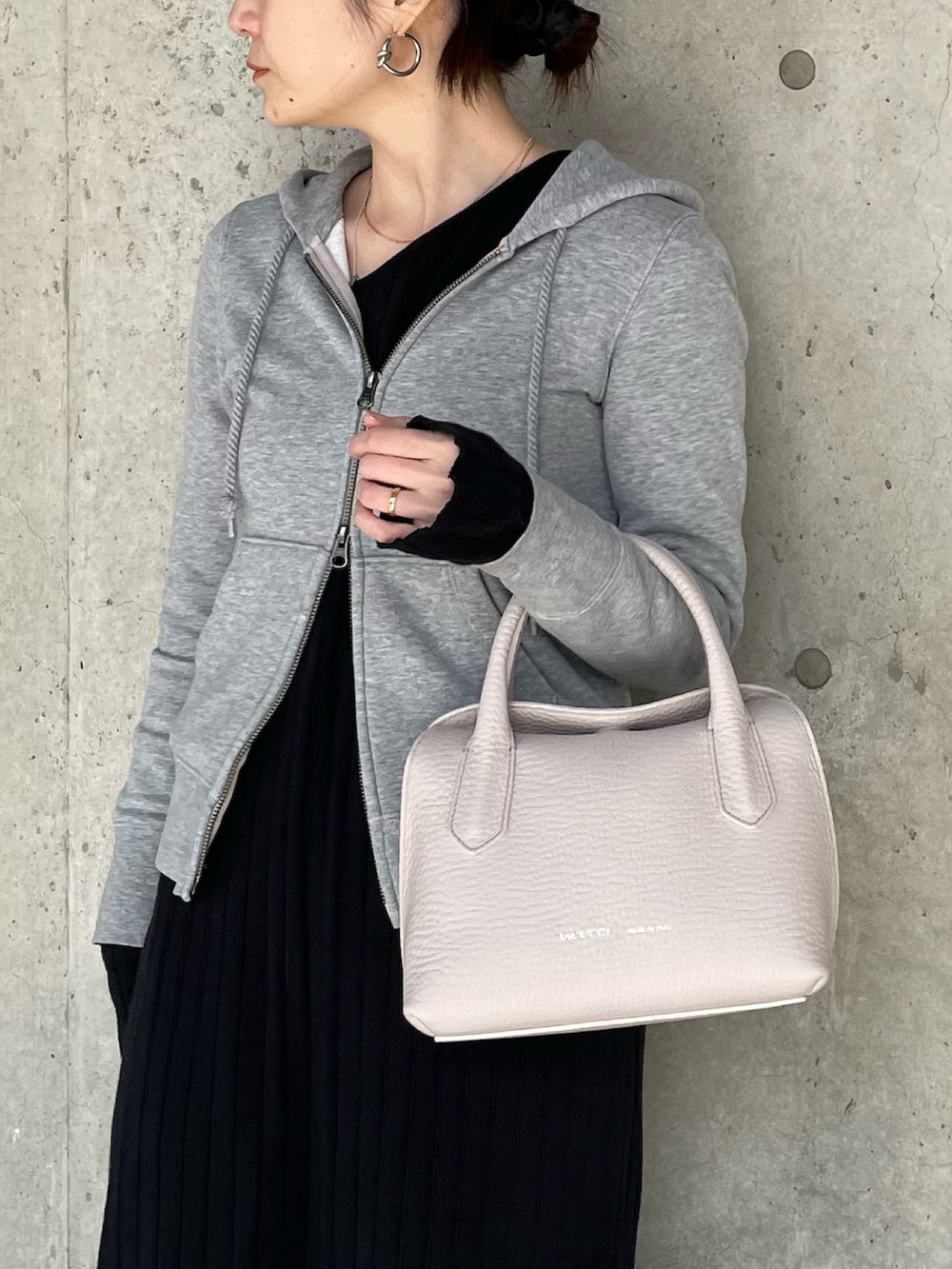 ピンク系のトートバッグを着用したレディースの冬コーディネートの2枚目の写真