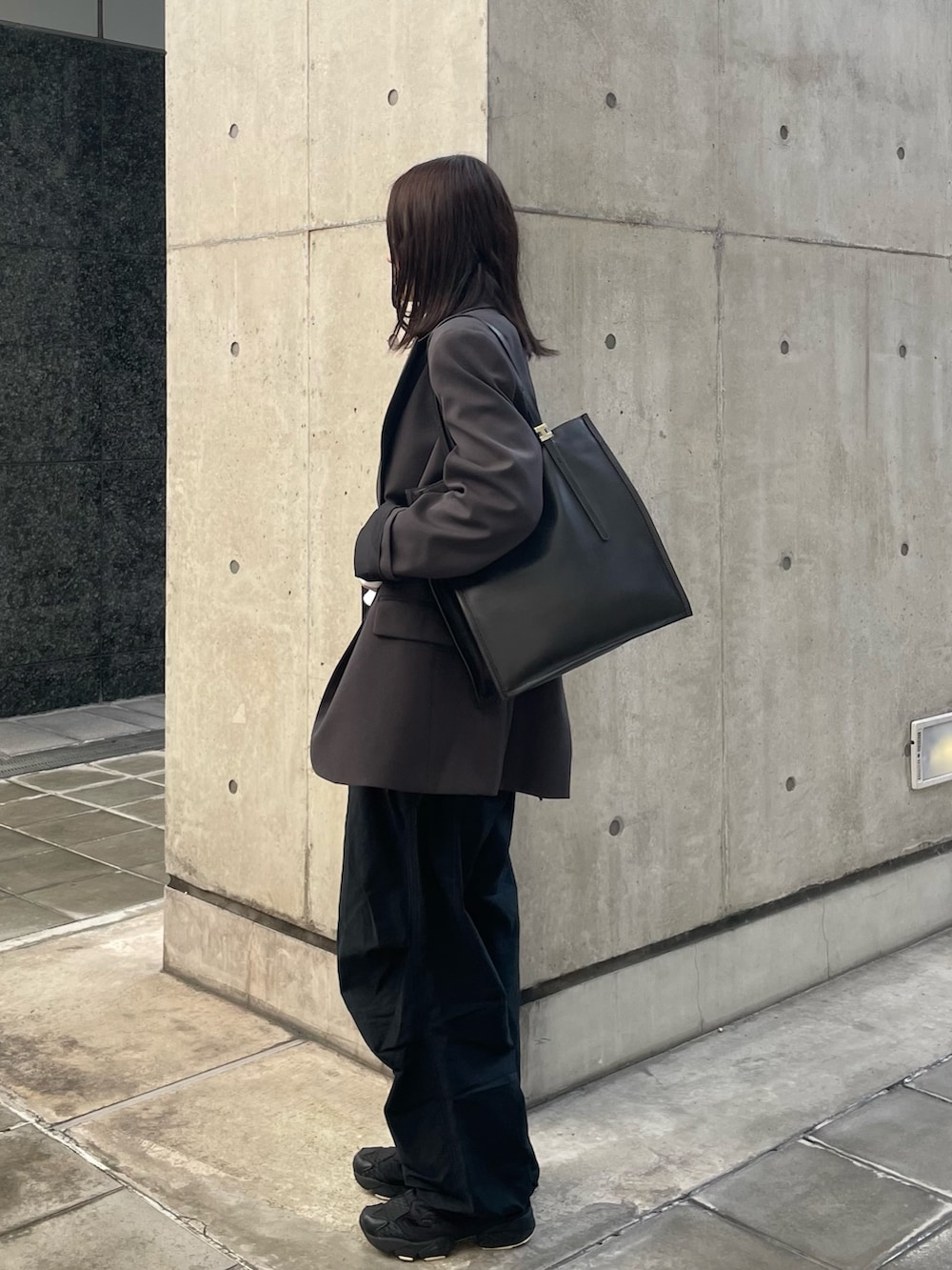 ブラウン系のトートバッグを着用したレディースの冬コーディネートの2枚目の写真