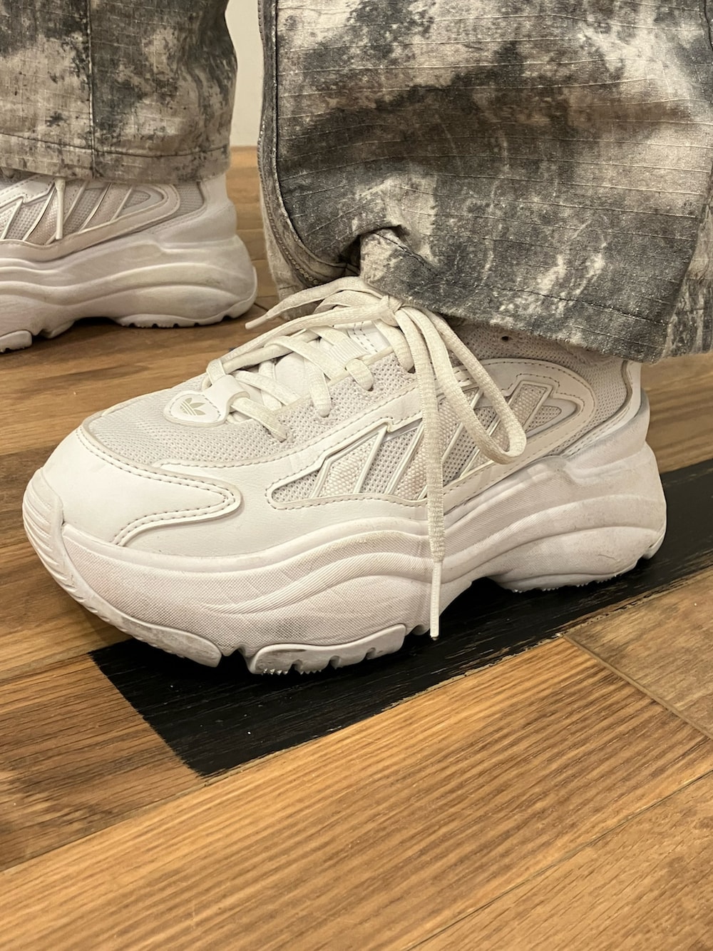 シルバー系のジャケット/アウター、ホワイト系のスニーカー、ブラック系のキャップを着用したレディースの冬コーディネートの4枚目の写真