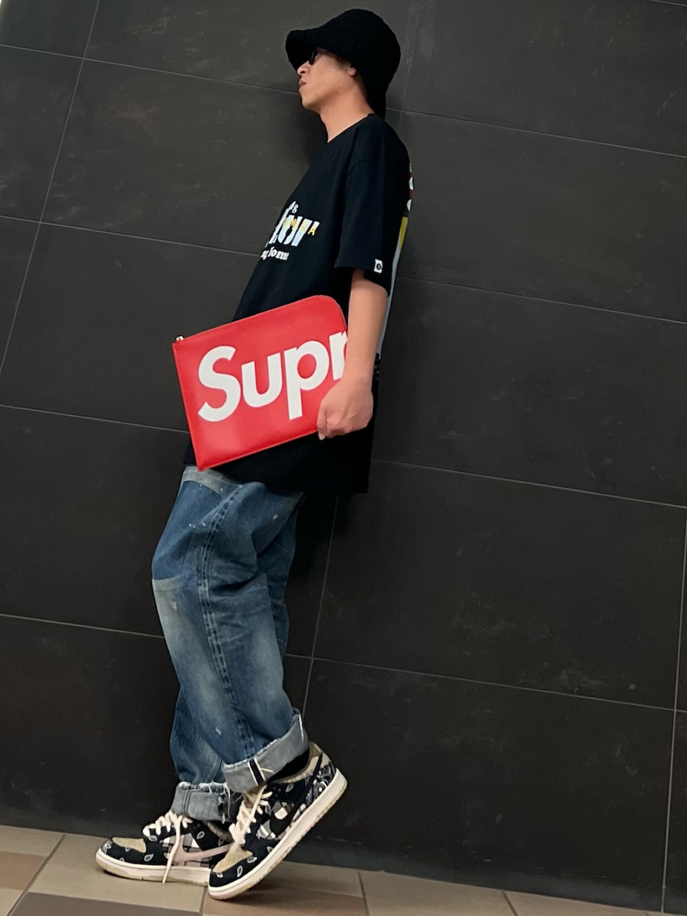 ブラック系のTシャツ/カットソー、レッド系のクラッチバッグ、レッド系のクラッチバッグを着用したメンズの夏コーディネートの3枚目の写真