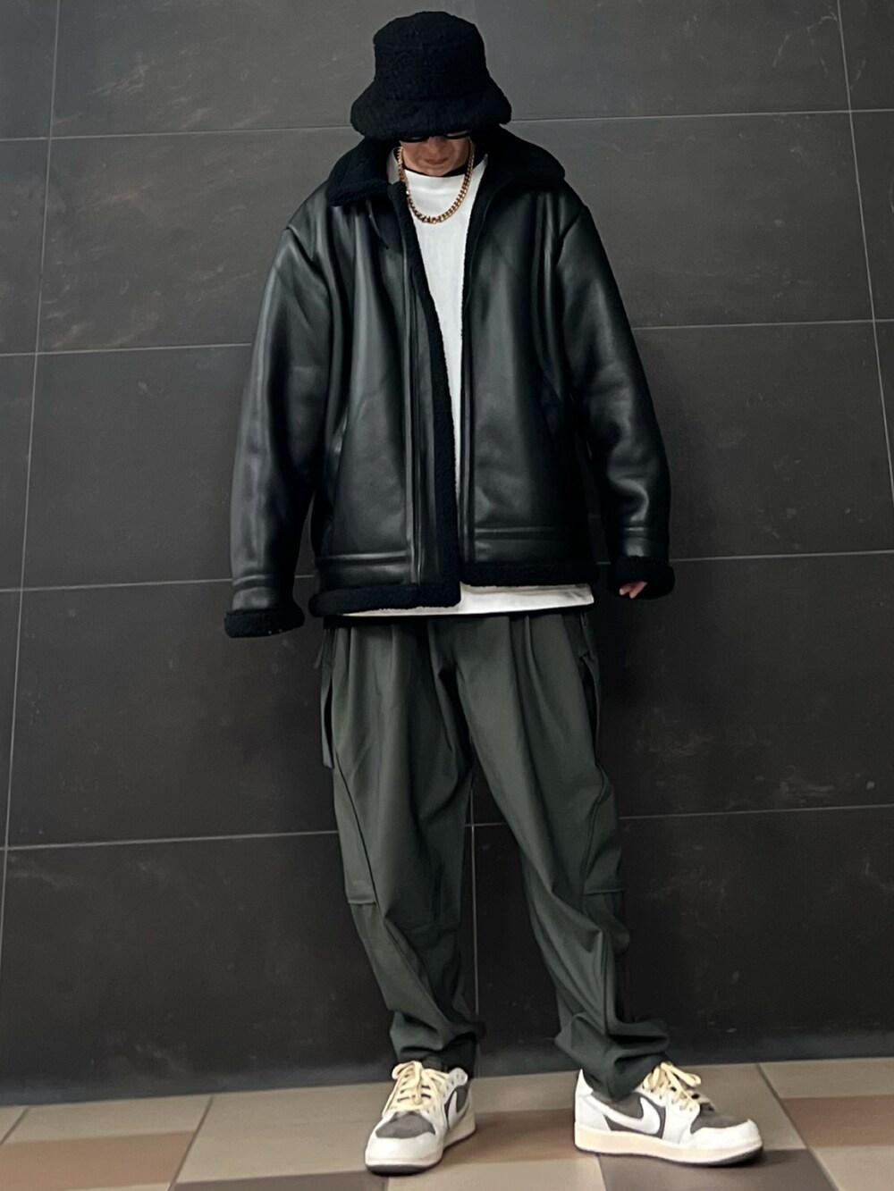 グレー系のスラックス、ホワイト系のTシャツ/カットソー、ブラック系のTシャツ/カットソーを着用したメンズの冬コーディネートの2枚目の写真