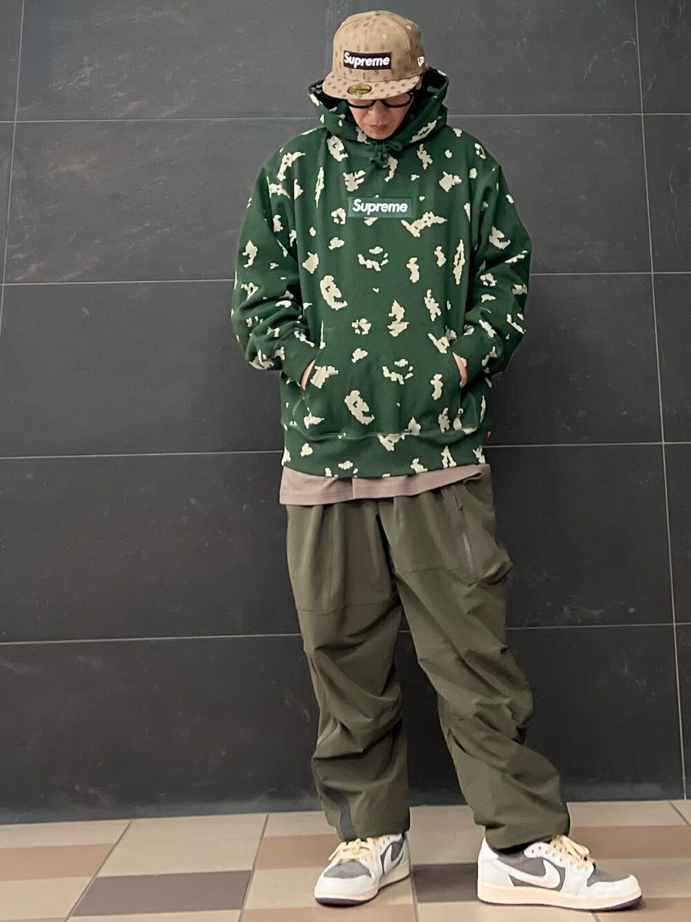 グリーン系のカーゴパンツ、シルバー系のダウンジャケット/コート、グレー系のスニーカーを着用したメンズの冬コーディネートの2枚目の写真