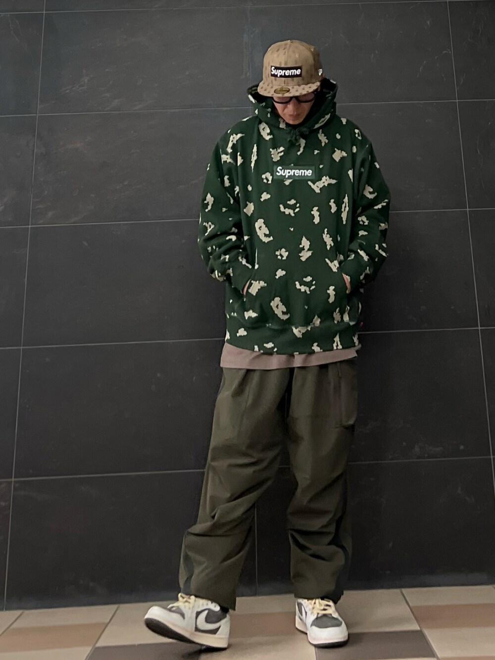 グリーン系のカーゴパンツ、シルバー系のダウンジャケット/コート、グレー系のスニーカーを着用したメンズの冬コーディネートの5枚目の写真