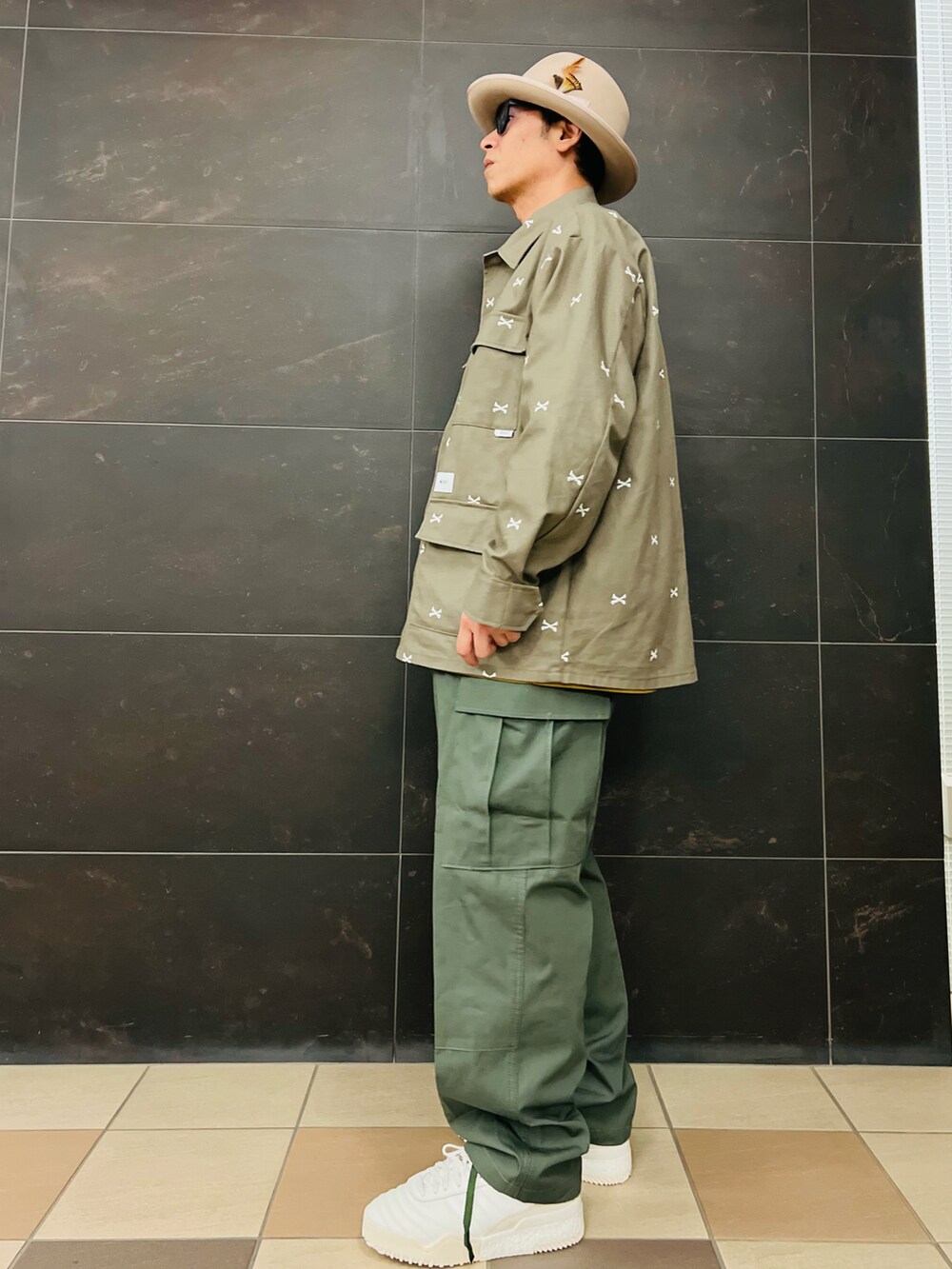 グリーン系のシャツ/ブラウス、グリーン系のカーゴパンツ、ホワイト系のスニーカーを着用したメンズの秋コーディネートの2枚目の写真