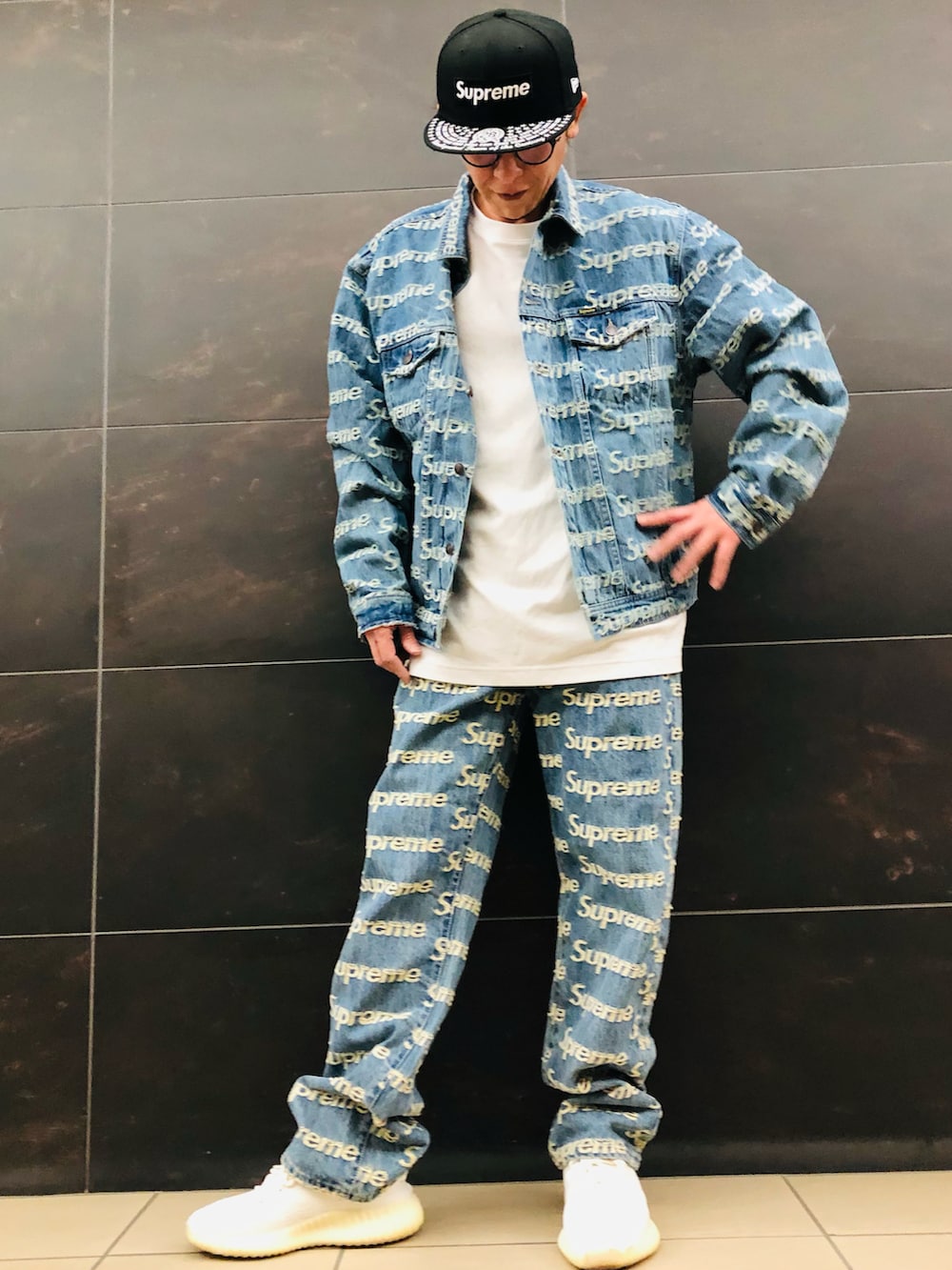 ブルー系のデニムパンツ、ブルー系のデニムジャケット、ホワイト系のスニーカーを着用したメンズの春コーディネートの3枚目の写真