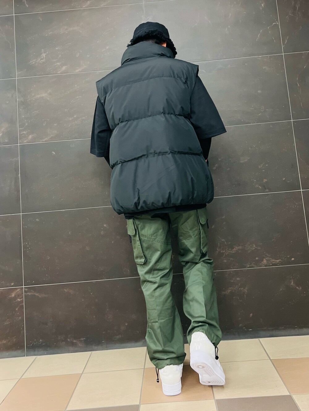 ブラック系のダウンベスト、ブラック系のTシャツ/カットソー、グリーン系のカーゴパンツを着用したメンズの秋コーディネートの3枚目の写真