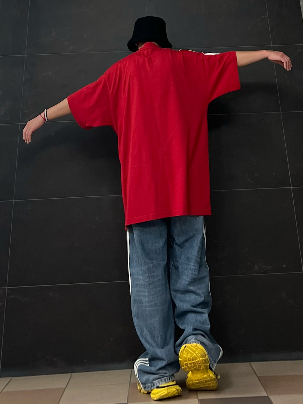 レッド系のTシャツ/カットソー、レッド系のTシャツ/カットソー、ブルー系のデニムパンツを着用したメンズの夏コーディネートの3枚目の写真