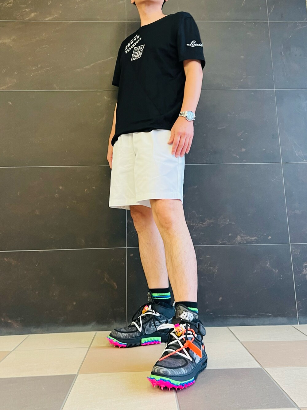 ブラック系のTシャツ/カットソー、ホワイト系のチノパンツ、ブラック系のスニーカーを着用したメンズの夏コーディネートの2枚目の写真