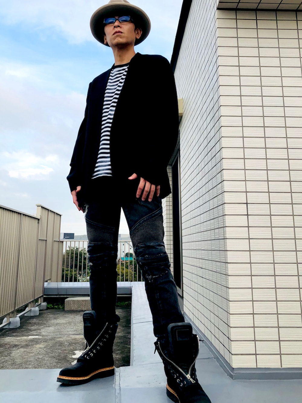 ブラック系のノーカラーコート、その他のTシャツ/カットソー、ブラック系のデニムパンツを着用したメンズの秋コーディネートの5枚目の写真