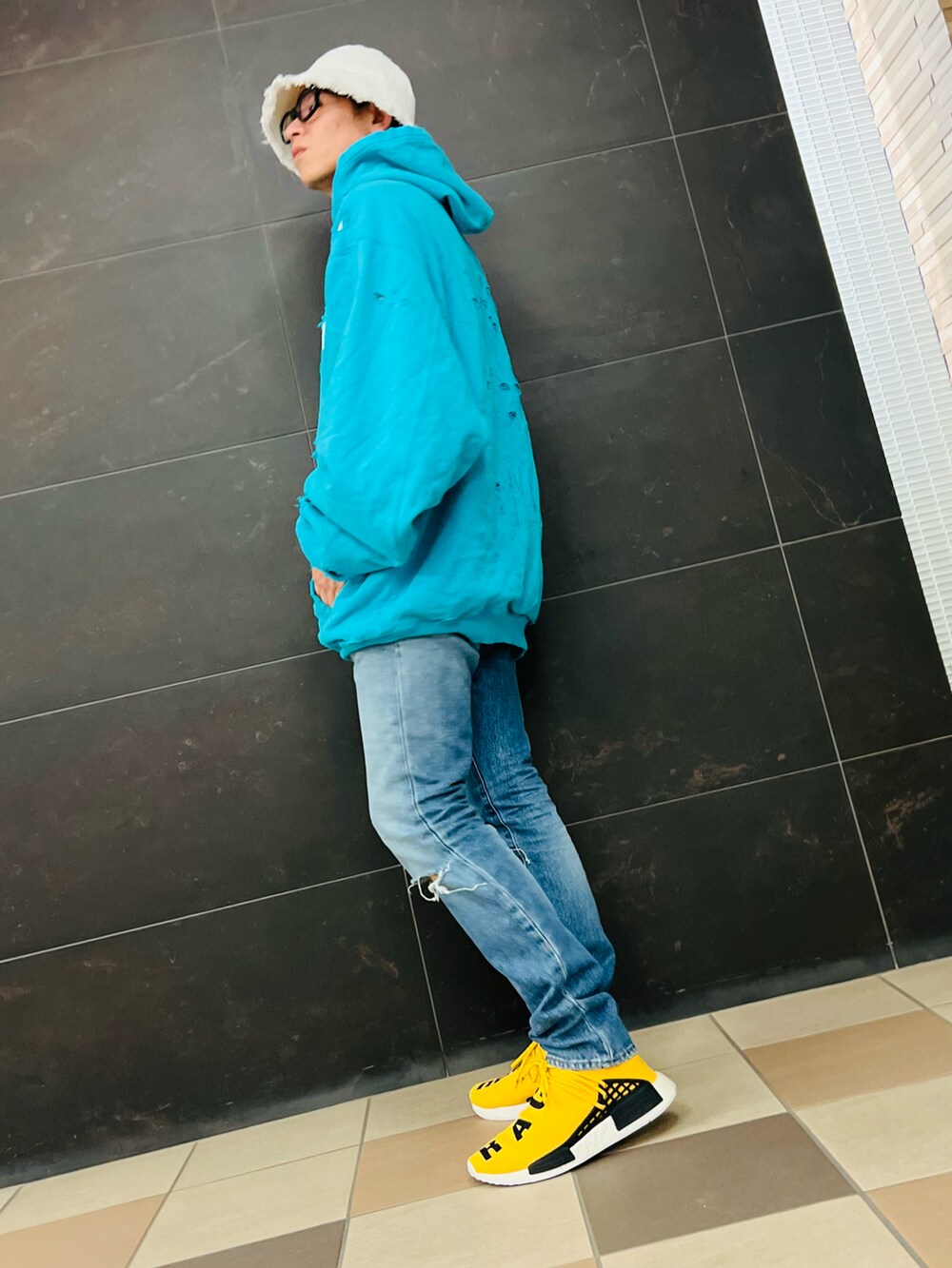 ブルー系のパーカー、ブルー系のデニムパンツ、イエロー系のスニーカーを着用したメンズの秋コーディネートの3枚目の写真