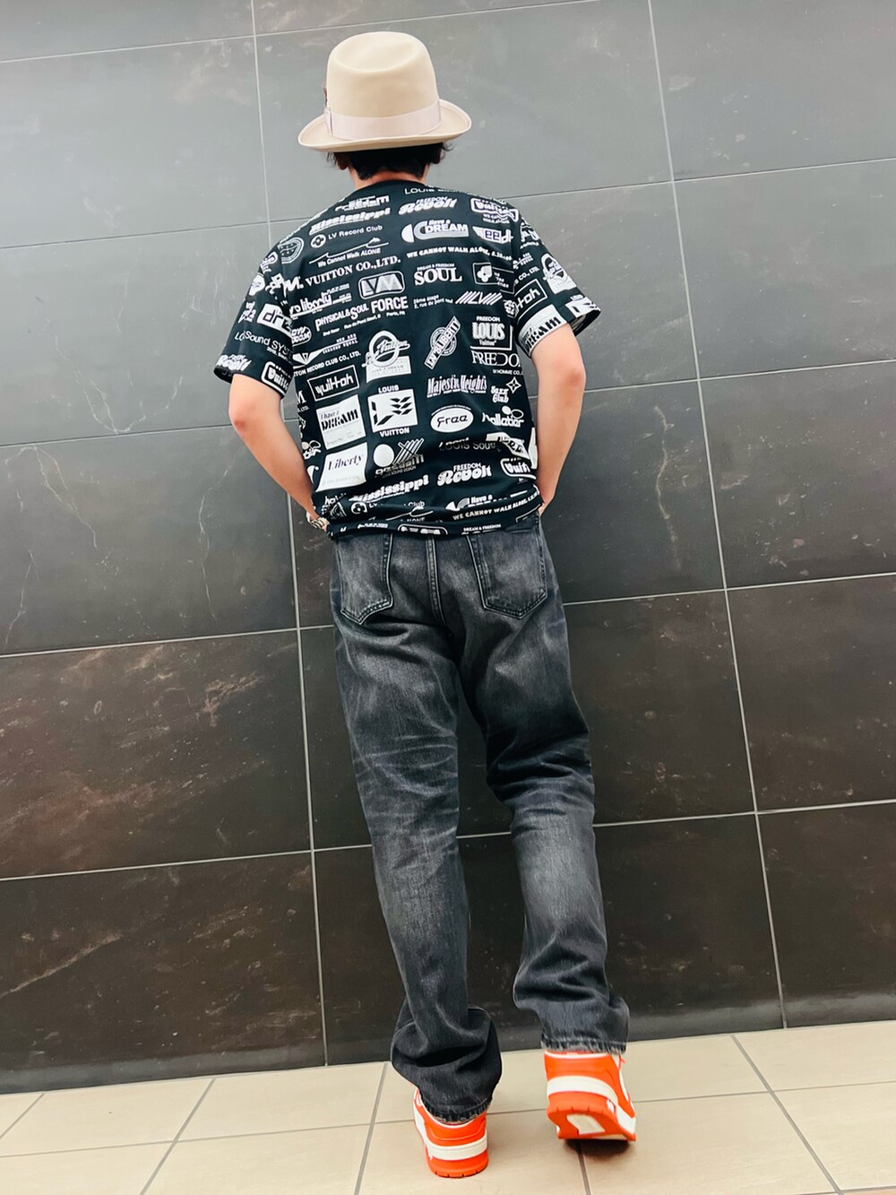 ブラック系のTシャツ/カットソー、ブラック系のデニムパンツ、オレンジ系のスニーカーを着用したメンズの夏コーディネートの3枚目の写真