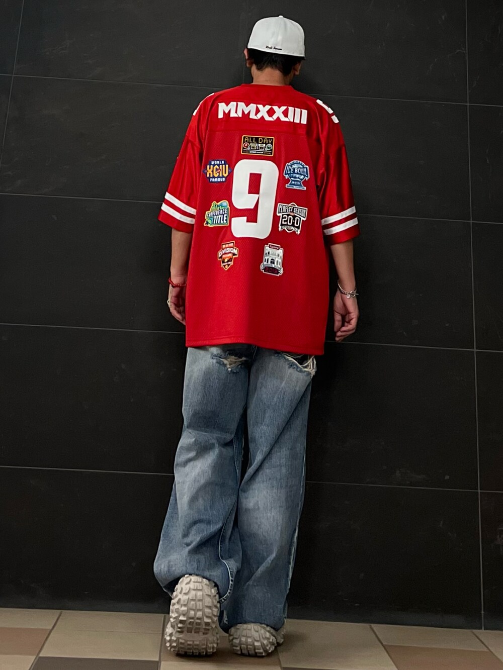 レッド系のシャツ/ブラウス、ブルー系のデニムパンツ、ベージュ系のスニーカーを着用したメンズの秋コーディネートの2枚目の写真