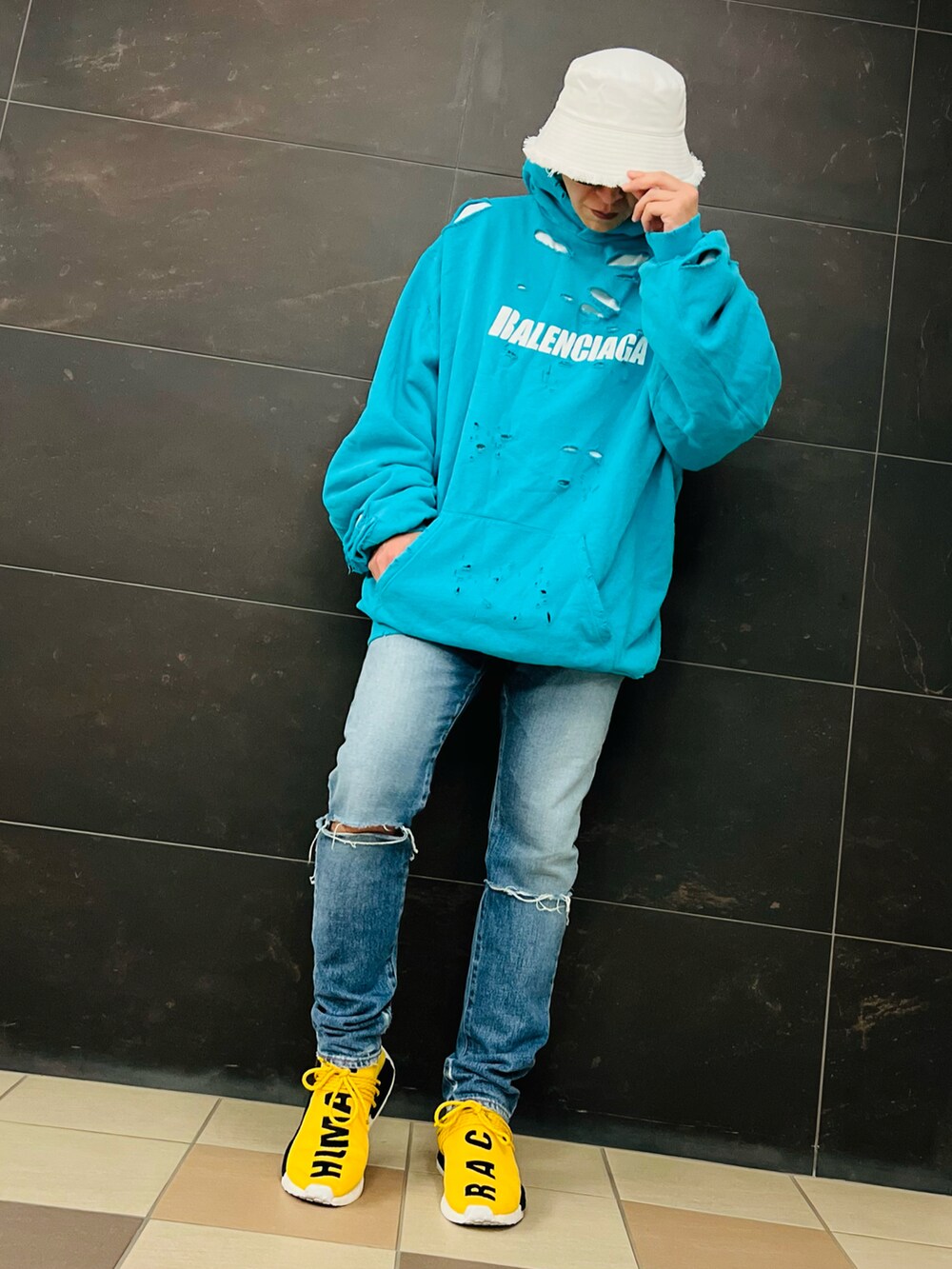 ブルー系のパーカー、ブルー系のデニムパンツ、イエロー系のスニーカーを着用したメンズの秋コーディネートの2枚目の写真