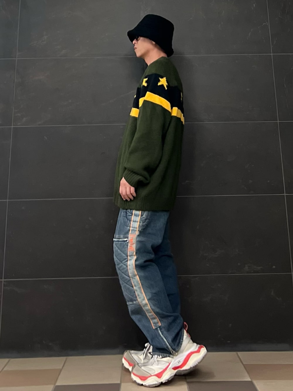 グリーン系のニット/セーター、ホワイト系のTシャツ/カットソー、ブルー系のデニムパンツを着用したメンズの春コーディネートの2枚目の写真