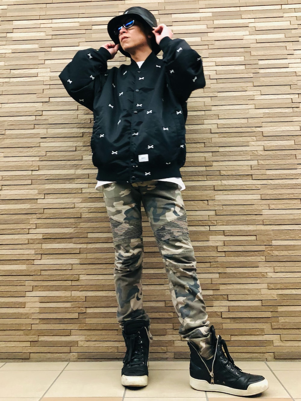 ブラック系のブルゾン、グリーン系のその他パンツ、ブラック系のスニーカーを着用したメンズの春コーディネートの2枚目の写真