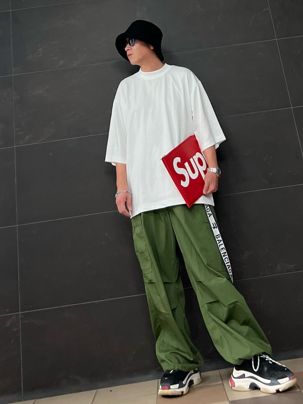 ホワイト系のTシャツ/カットソー、レッド系のクラッチバッグ、レッド系のクラッチバッグを着用したメンズの夏コーディネートの2枚目の写真