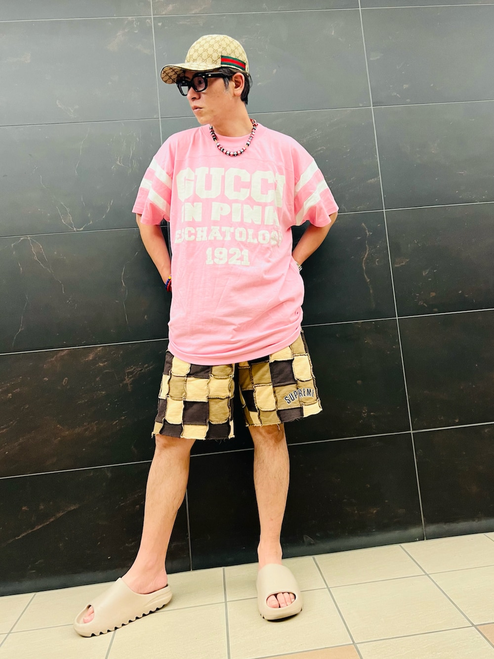 ピンク系のTシャツ/カットソー、ブラウン系のスウェットパンツ、ベージュ系のスニーカーを着用したメンズの夏コーディネートの2枚目の写真